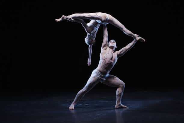 Acrobat duo performing a balance lift in Southeast Asia Acrobat duo performing a balance lift in Southeast Asia