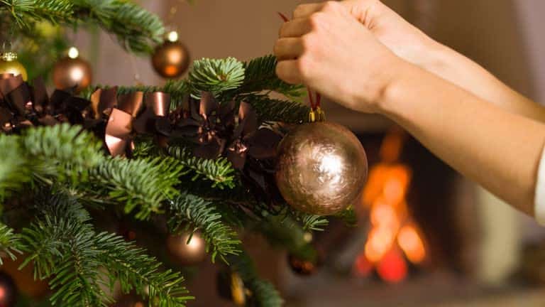 Hanging a bauble on a Christmas tree in Southeast Asia