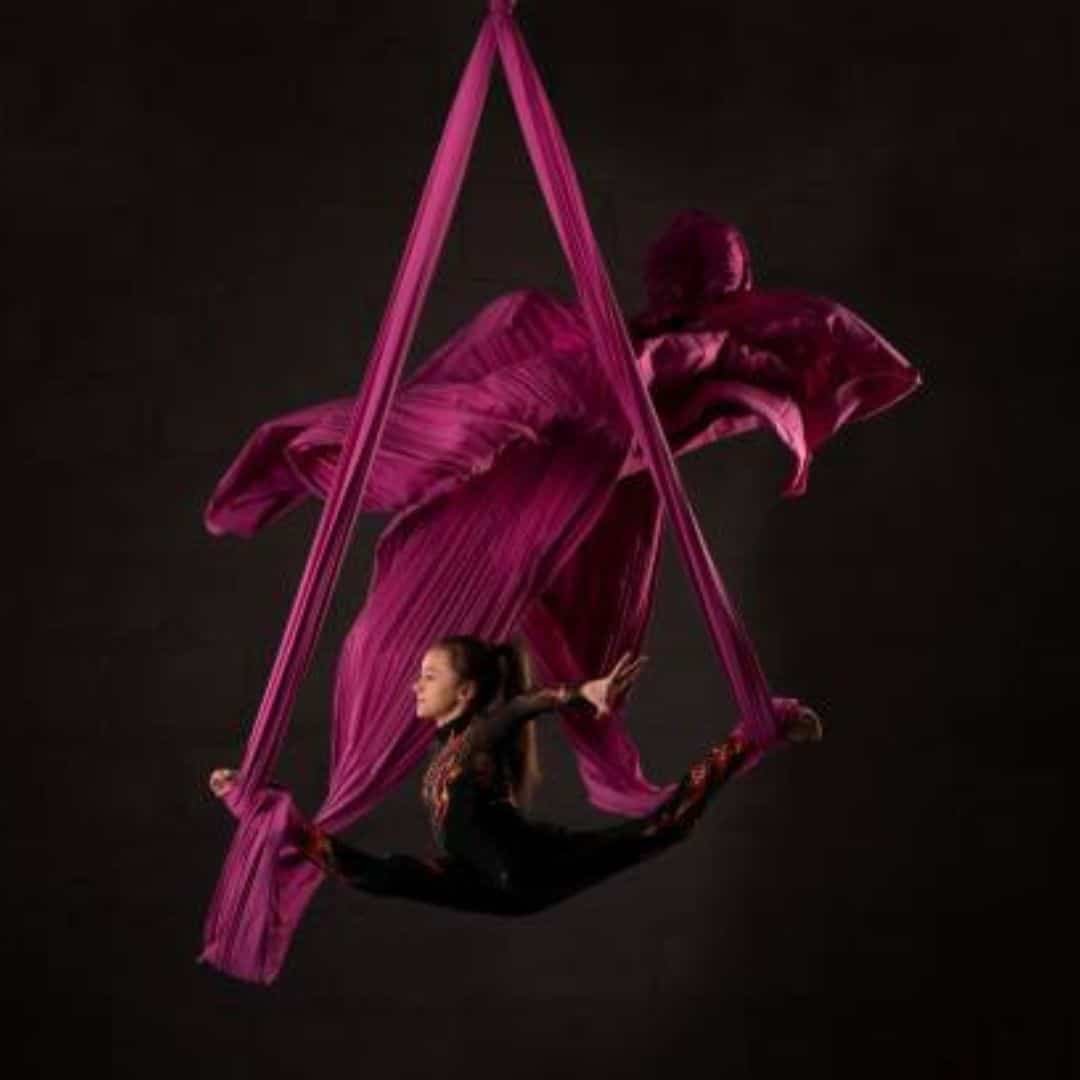 Aerialist in red silks above the stage in Southeast Asia Aerialist in red silks above the stage in Southeast Asia