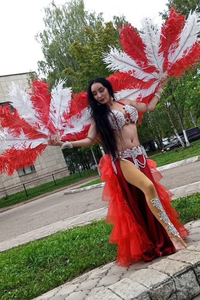 Belly dancer with red feather fans in Southeast Asia
