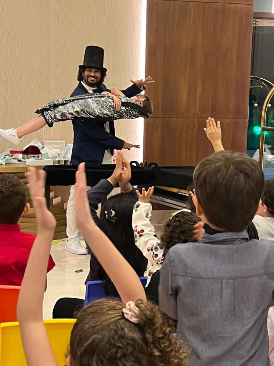 Magician entertaining excited children at a party in Southeast Asia