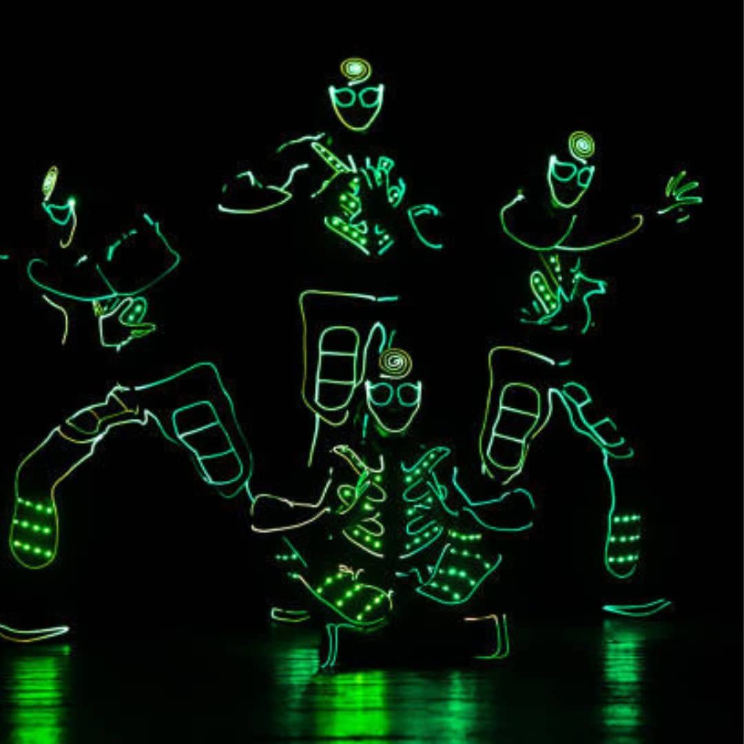 Green LED robot dancers on a dark stage in Southeast Asia