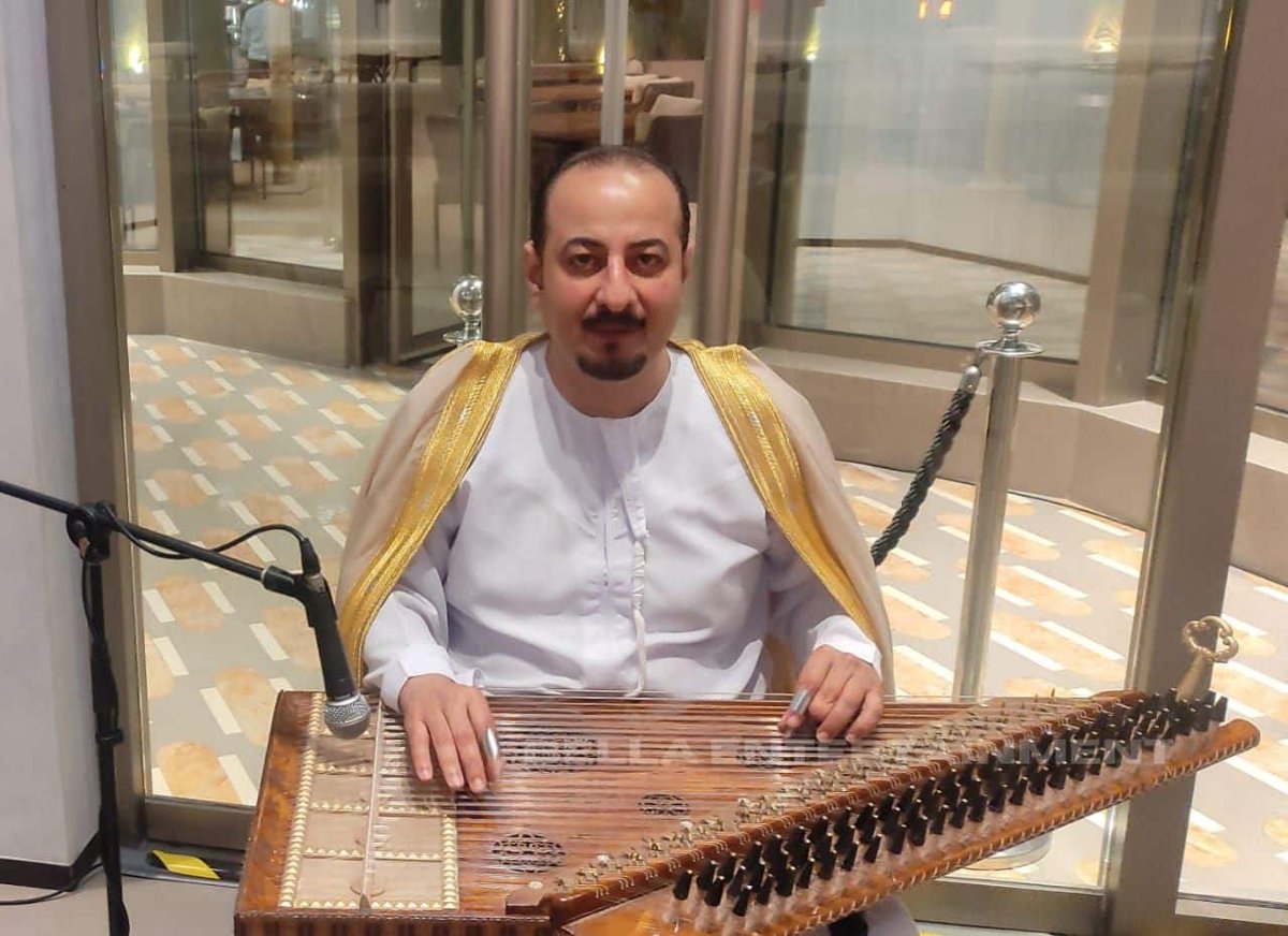 Qanun player performing at a hotel event in Southeast Asia