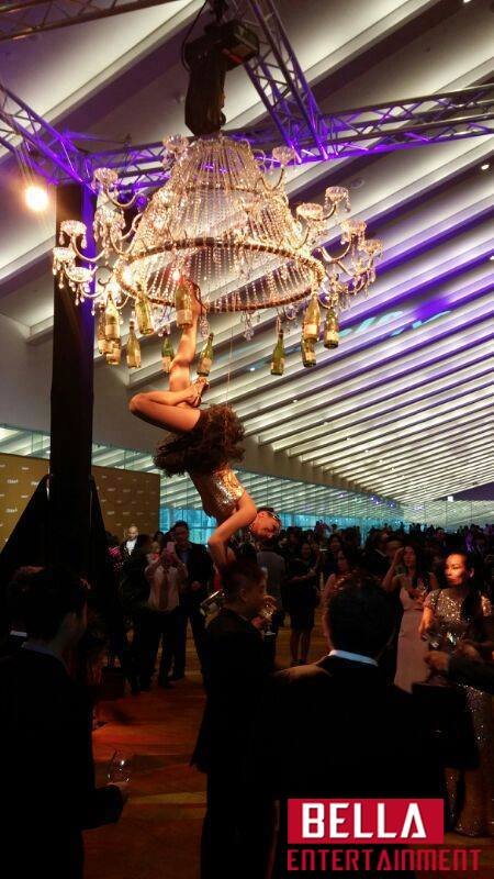 Aerial acrobat performing above guests at a gala in Southeast Asia